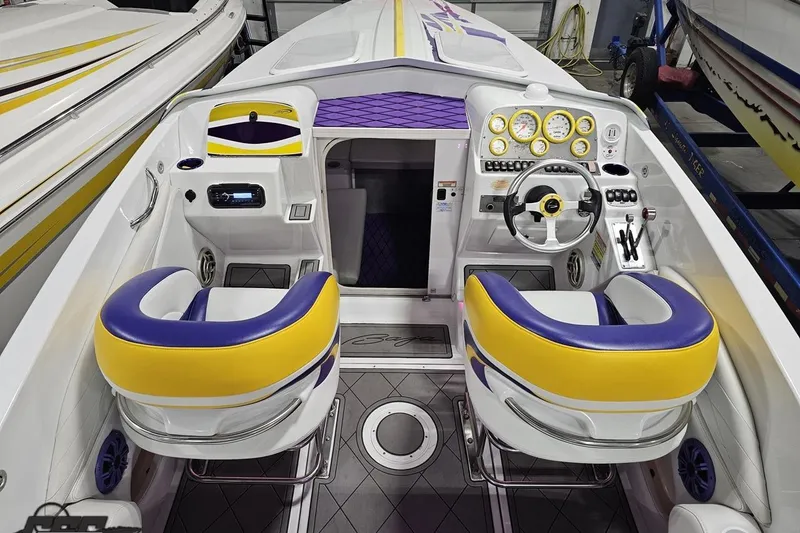 Slide: The Image of 2003 Baja 25 Outlaw boat interior with vibrant yellow and purple seating, modern dashboard controls. - 51