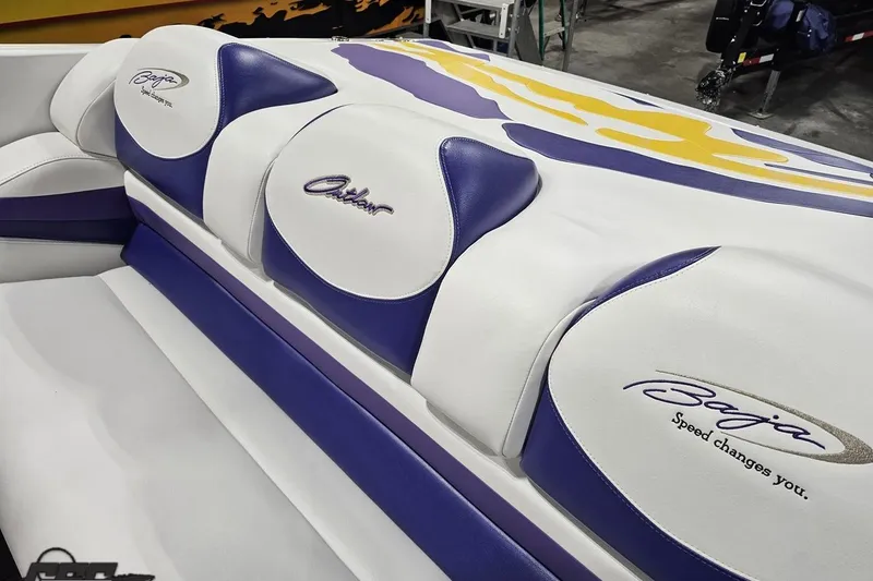 Slide: The Image of 2003 Baja 25 Outlaw boat interior with purple and white seating design. - 54