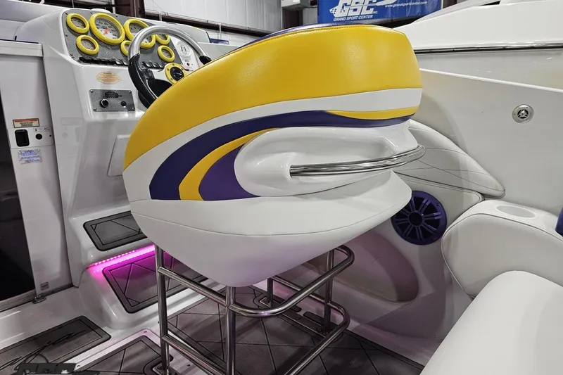 Slide: The Image of 2003 Baja 25 Outlaw boat interior with vibrant yellow and white seating, modern dashboard. - 56