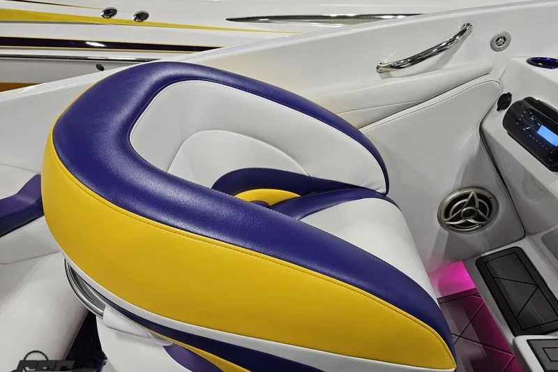 Slide: The Image of 2003 Baja 25 Outlaw boat interior with vibrant yellow and purple seating. - 59