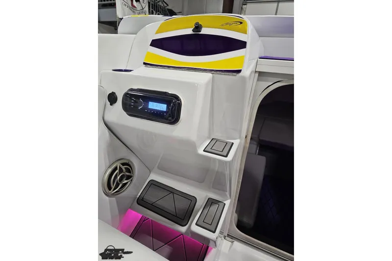 Slide: The Image of 2003 Baja 25 Outlaw boat interior with stereo system and vibrant lighting. - 60
