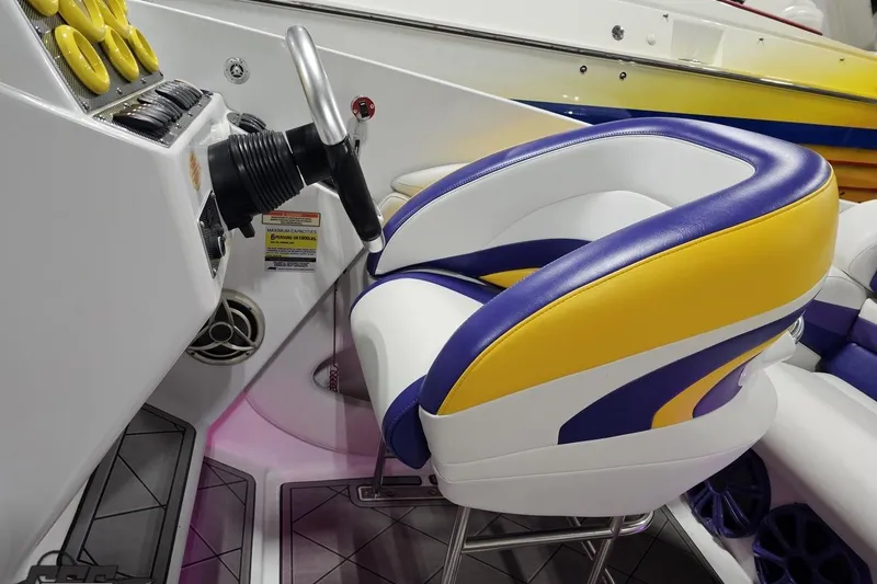 Slide: The Image of 2003 Baja 25 Outlaw boat interior with vibrant yellow and purple seating. - 67