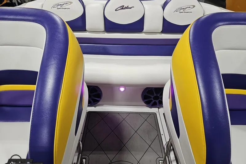 Slide: The Image of Interior of a 2003 Baja 25 Outlaw boat with vibrant purple and yellow seating. - 70