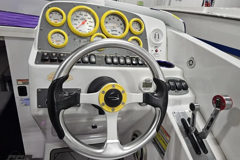Slide: The Image of 2003 Baja 25 Outlaw boat dashboard with steering wheel and control panel. - 74