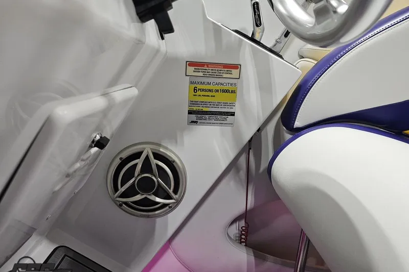 Slide: The Image of 2003 Baja 25 Outlaw boat interior with speaker and capacity warning label. - 75