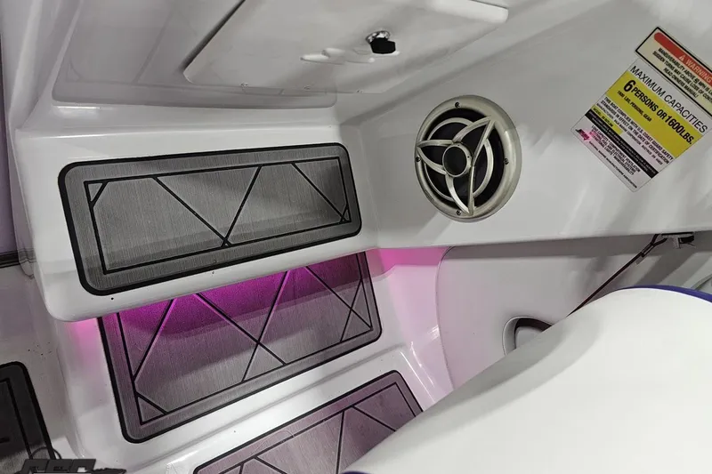 Slide: The Image of 2003 Baja 25 Outlaw boat interior with speaker, steps, and capacity warning label. - 76