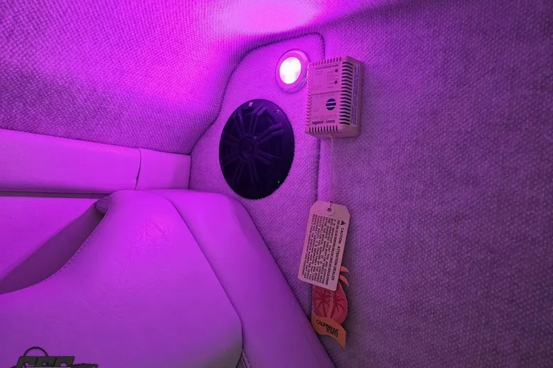 Slide: The Image of Interior of 2003 Baja 25 Outlaw boat with purple lighting and speaker. - 80