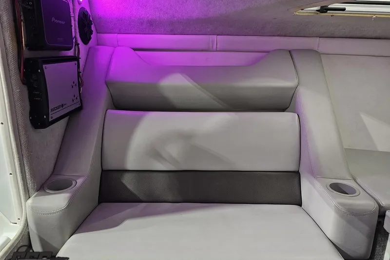 Slide: The Image of 2003 Baja 25 Outlaw interior with gray seating, cup holders, and audio equipment. - 81