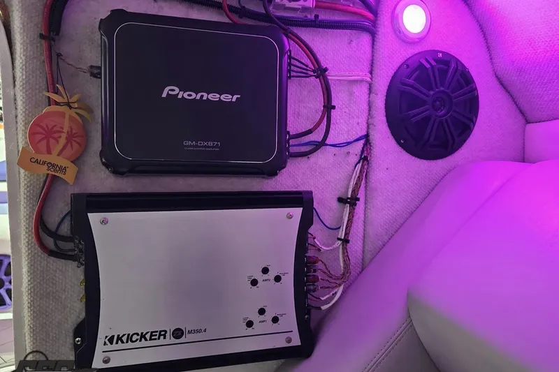 Slide: The Image of 2003 Baja 25 Outlaw boat interior with Pioneer and Kicker audio systems, purple lighting. - 82