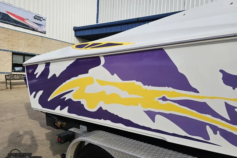 Slide: The Image of 2003 Baja 25 Outlaw boat with vibrant purple and yellow graphics on the side. - 9
