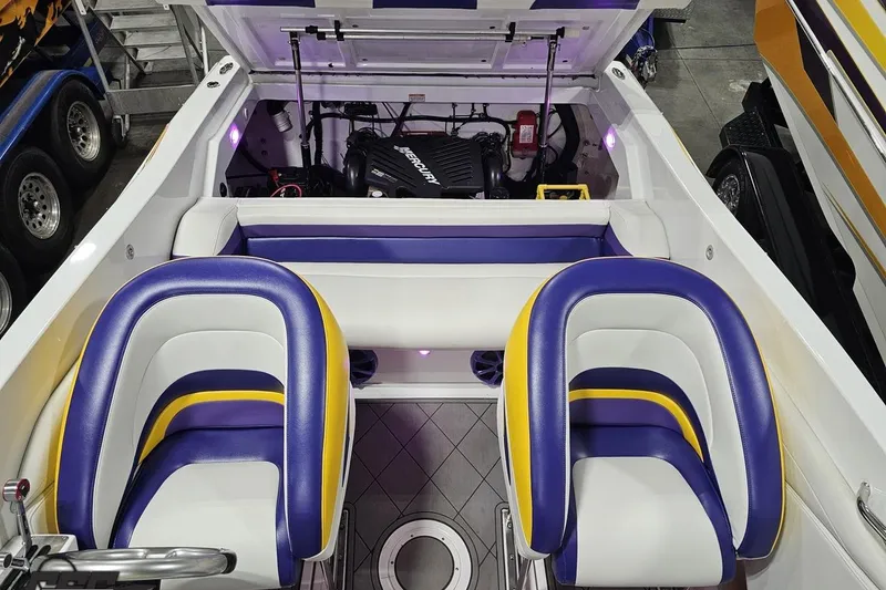 Slide: The Image of 2003 Baja 25 Outlaw boat interior with vibrant seating and visible engine compartment. - 91