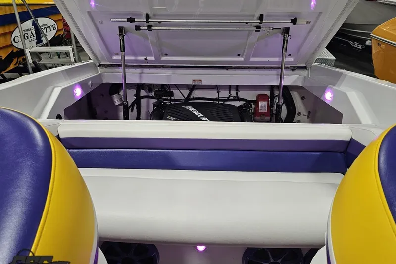 Slide: The Image of 2003 Baja 25 Outlaw boat engine compartment with vibrant seating and ambient lighting. - 92