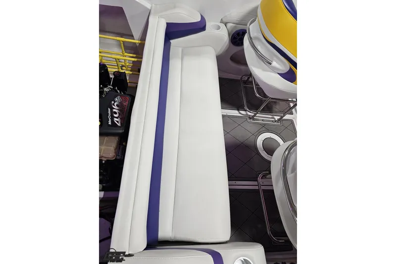 Slide: The Image of 2003 Baja 25 Outlaw boat interior with white and blue seating, featuring a MerCruiser engine. - 99