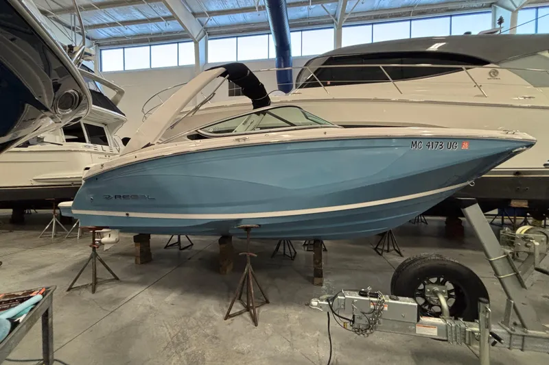 The Image of 2018 Regal 23 OBX boat in storage, blue hull, indoor facility. - 0
