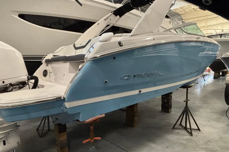 Slide: The Image of 2018 Regal 23 OBX boat interior with white and black seating in a showroom. - 1