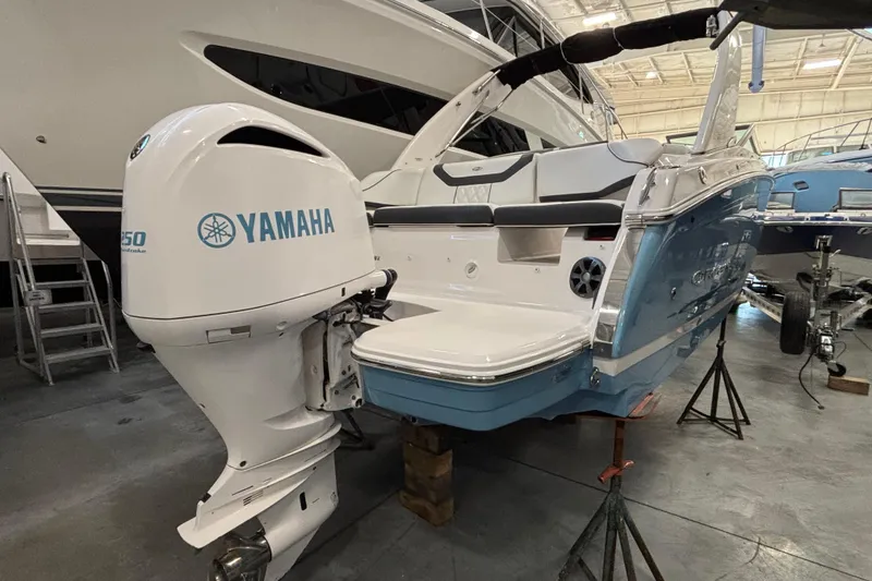 Slide: The Image of 2018 Regal 23 OBX boat interior with white seating and wooden table. - 2