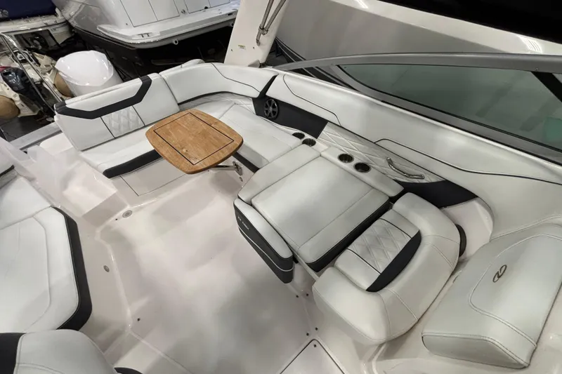 Slide: The Image of 2018 Regal 23 OBX boat interior with white seating and glass windshields in a showroom. - 21