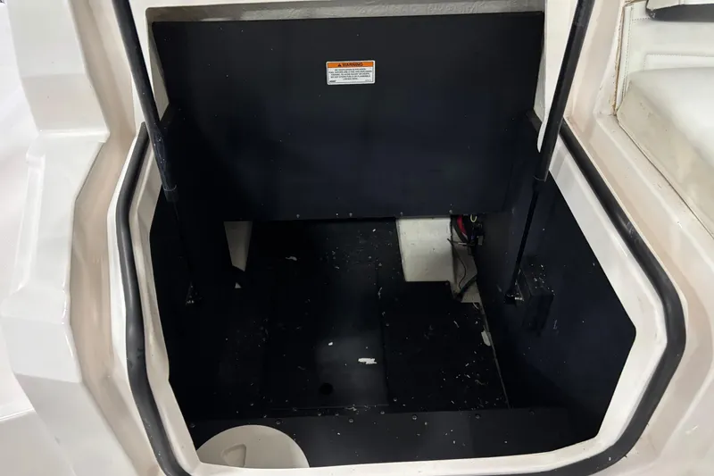 Slide: The Image of 2018 Regal 23 OBX boat storage compartment with black interior and white exterior. - 23