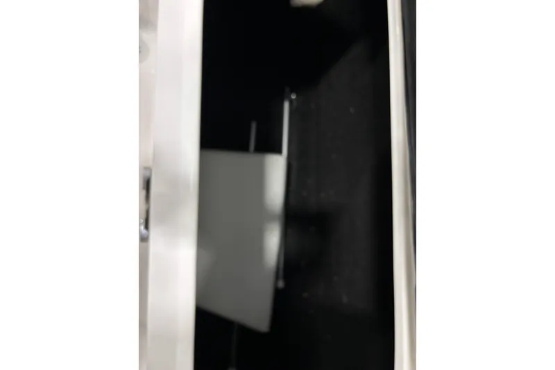 Slide: The Image of Storage compartment inside 2018 Regal 23 OBX boat, featuring a sleek white interior. - 24