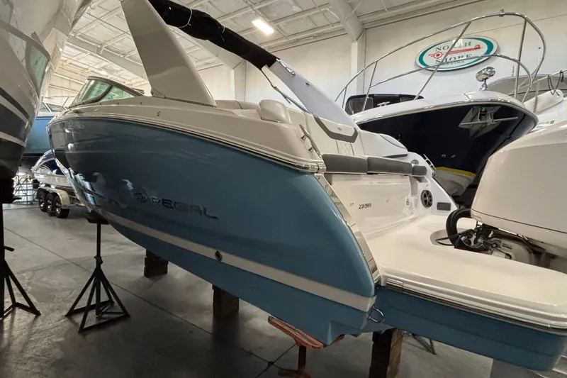Slide: The Image of 2018 Regal 23 OBX boat in showroom, featuring sleek blue and white design. - 5