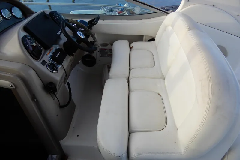 Slide: The Image of 2004 Sea Ray 300 Sundancer cockpit with white seating and control panel. - 12