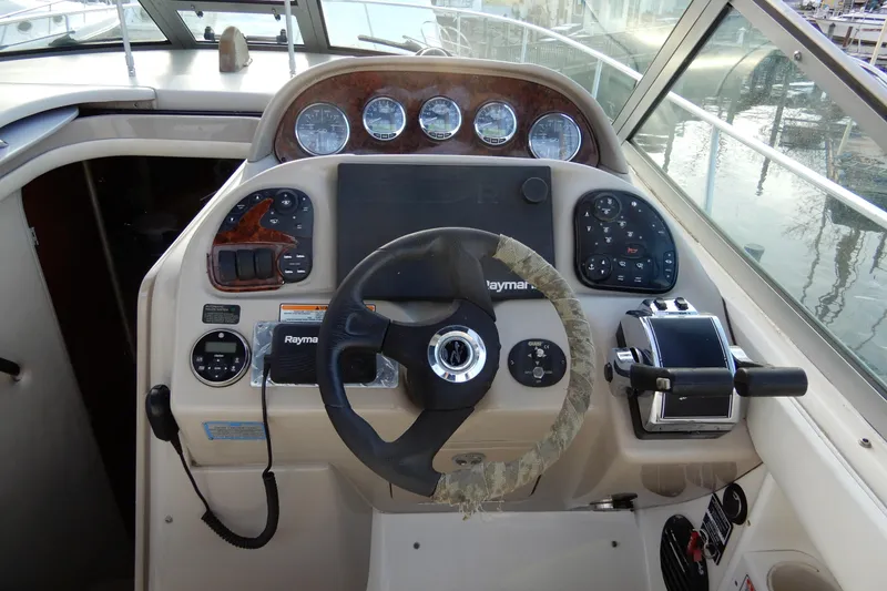 Slide: The Image of 2004 Sea Ray 300 Sundancer helm with steering wheel and control panel. - 14