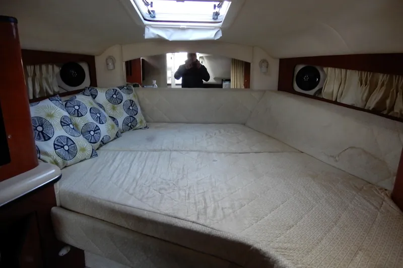 Slide: The Image of Interior cabin of 2004 Sea Ray 300 Sundancer with cozy bedding and decorative pillows. - 3