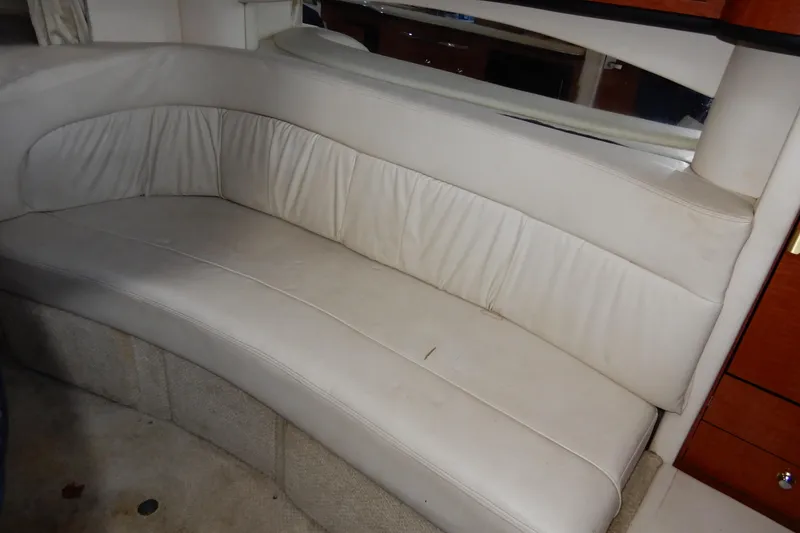 Slide: The Image of 2004 Sea Ray 300 Sundancer interior with beige leather seating and wooden cabinetry. - 7