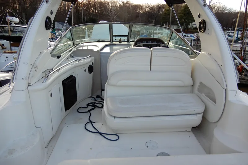 Slide: The Image of 2004 Sea Ray 300 Sundancer boat interior with white seating and dashboard view. - 9