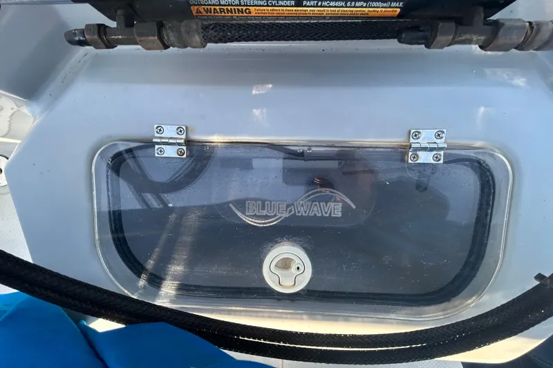 Slide: The Image of 2017 Blue Wave 1900 STL boat compartment with clear cover and warning label. - 10