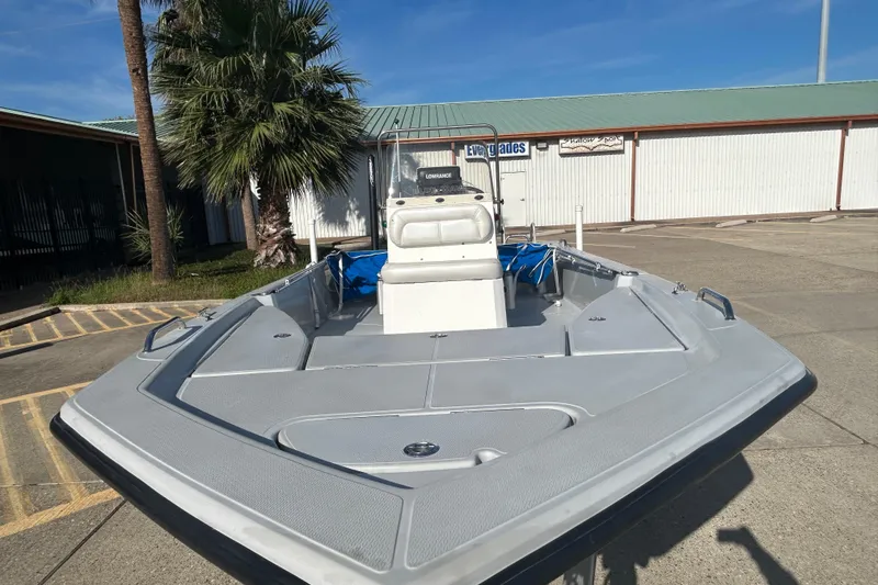 Slide: The Image of 2017 Blue Wave 1900 STL boat in a sunny outdoor setting, near palm trees. - 2