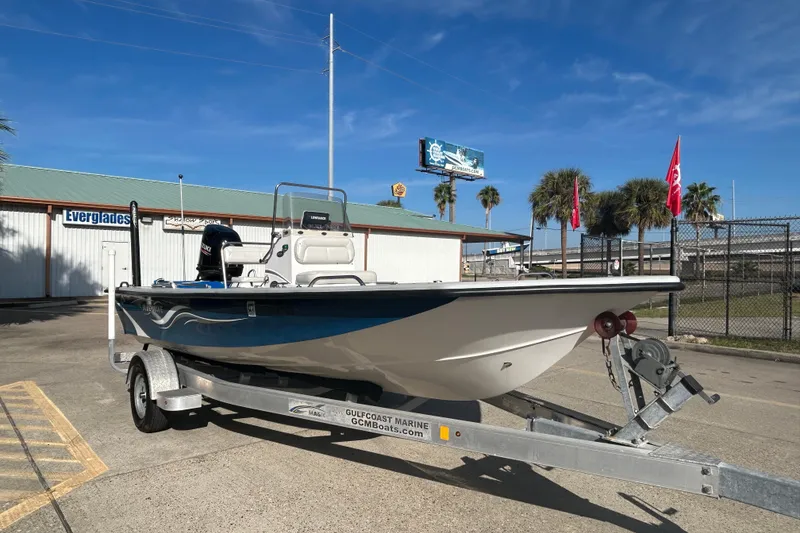 Slide: The Image of 2017 Blue Wave 1900 STL boat on trailer, parked outdoors under clear blue sky. - 3