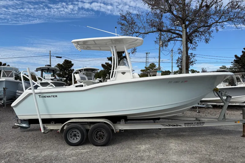 The Image of 2014 Tidewater 230 LXF boat on trailer, parked outdoors under blue sky. - 1