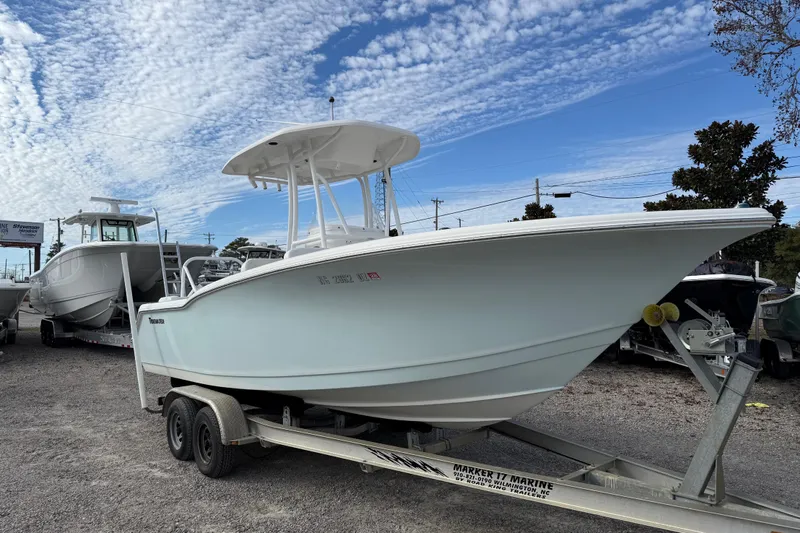 Slide: The Image of 2014 Tidewater 230 LXF boat on trailer under a partly cloudy sky. - 2