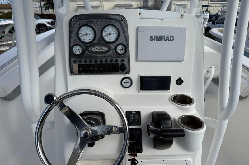 Slide: The Image of 2014 Tidewater 230 LXF boat dashboard with steering wheel, gauges, and Simrad display. - 20