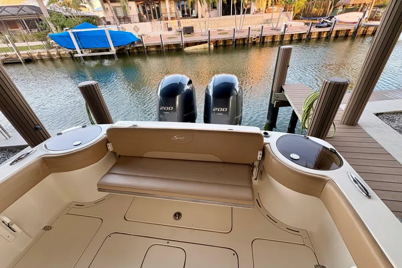 Slide: The Image of 2019 Scout 275 LXF boat with twin 200 horsepower engines docked by the water. - 3