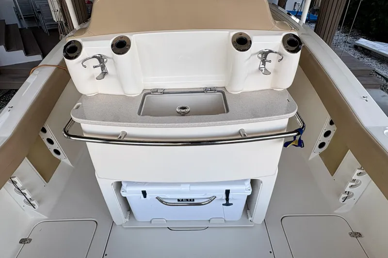 Slide: The Image of 2019 Scout 275 LXF boat interior with sink, rod holders, and storage. - 4