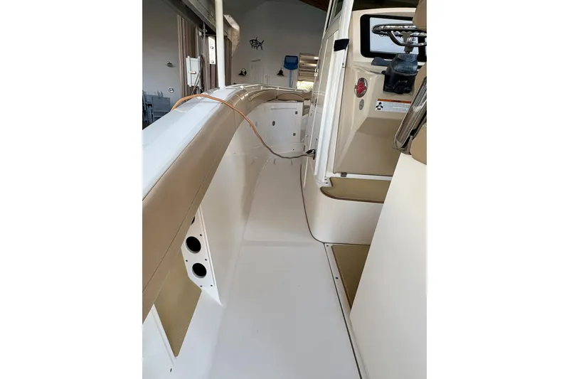 Slide: The Image of 2019 Scout 275 LXF boat interior with beige seating and steering console. - 8