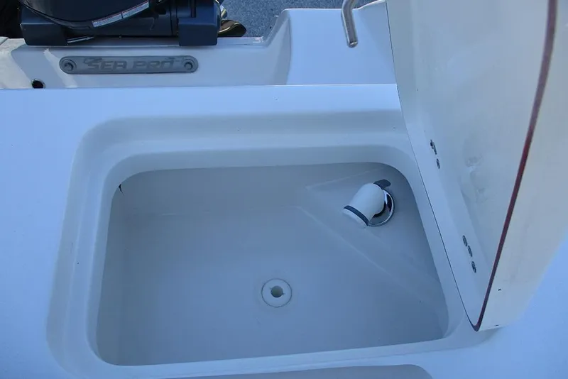 Slide: The Image of 2026 Sea Pro 262 Offshore boat compartment with open lid and visible drain. - 32