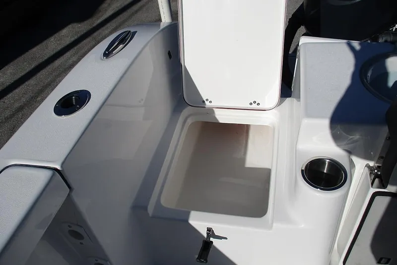 Slide: The Image of 2026 Sea Pro 262 Offshore boat storage compartment with open lid and cup holder. - 37
