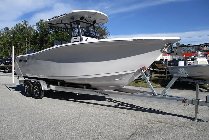 Slide: The Image of 2026 Sea Pro 262 Offshore boat on trailer, parked outdoors under clear sky. - 5