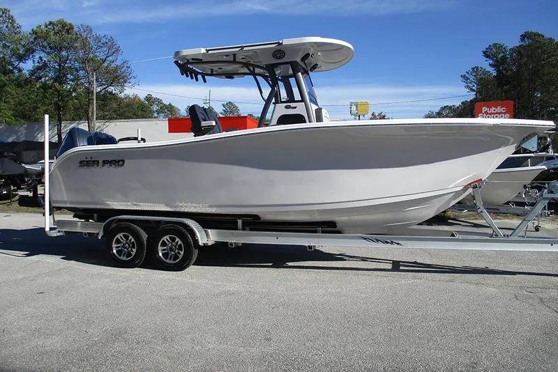 Slide: The Image of 2026 Sea Pro 262 Offshore boat on trailer, parked outdoors under clear sky. - 6