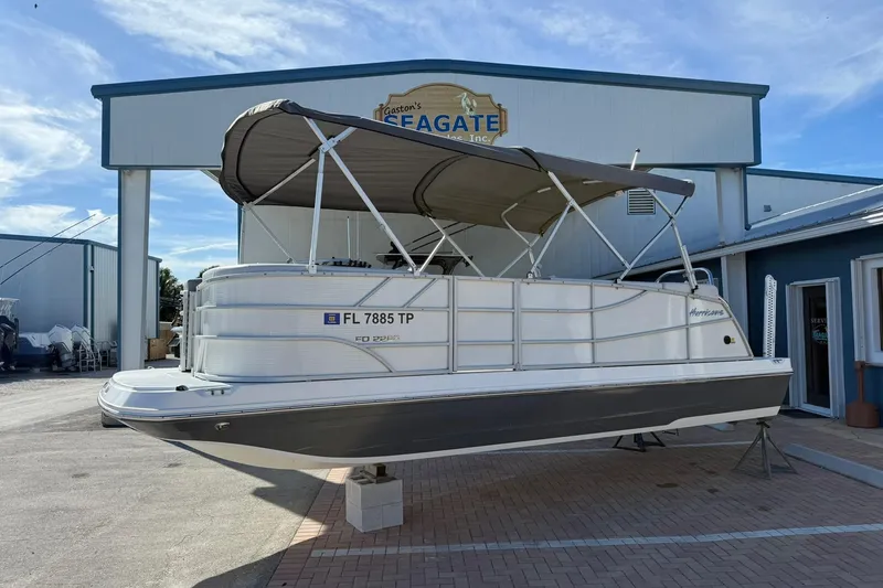 The Image of 2023 Hurricane FunDeck 2260 RE OB boat displayed outside a marine dealership. - 1