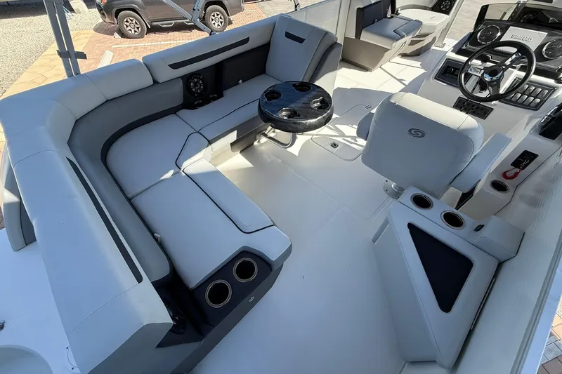 Slide: The Image of 2023 Hurricane FunDeck 2260 RE OB boat interior with plush seating and modern dashboard. - 10