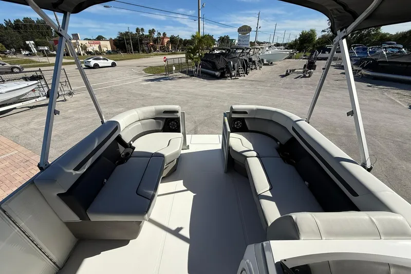 Slide: The Image of 2023 Hurricane FunDeck 2260 RE OB boat with spacious seating and canopy in a marina setting. - 20