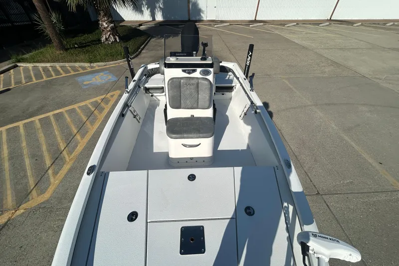 Slide: The Image of 2024 Avid 21 FS boat with seating and control console, parked on concrete. - 14