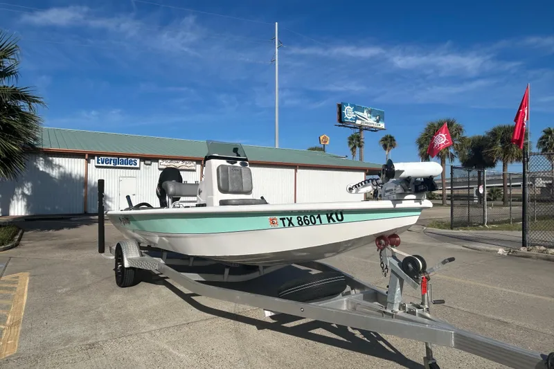 Slide: The Image of 2024 Avid 21 FS boat on trailer, parked outdoors under clear blue sky. - 7