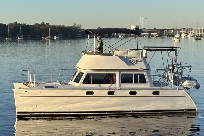 The Image of 2006 PDQ 34 Power Catamaran on calm water, featuring sleek design and spacious deck. - 0