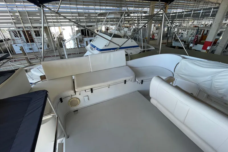 Slide: The Image of 2006 PDQ 34 Power Catamaran interior with white seating in a marina setting. - 15