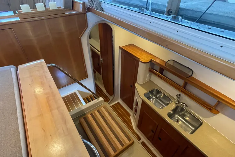 Slide: The Image of 2006 PDQ 34 Power Catamaran interior with wooden cabinetry and dual sink kitchen area. - 31